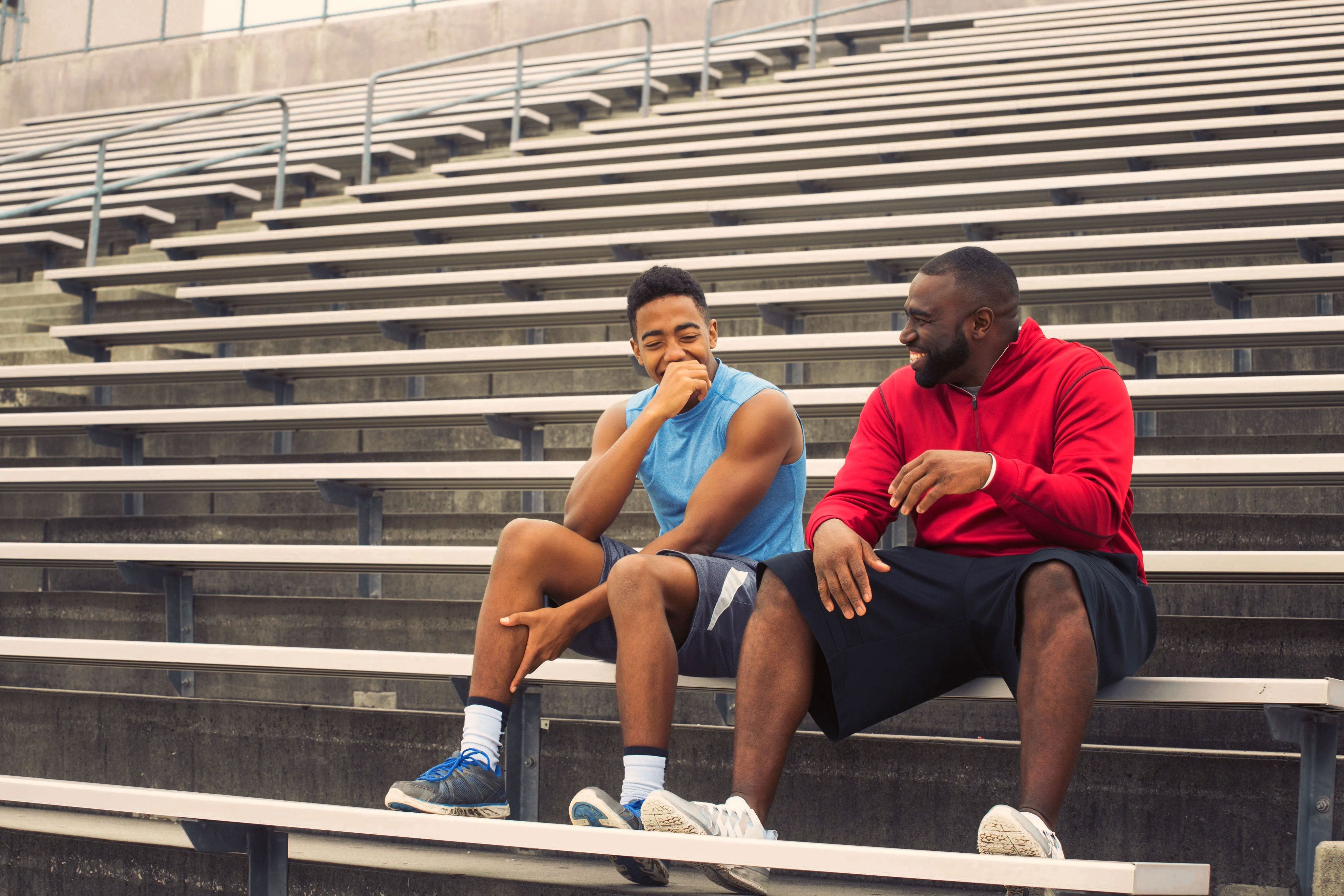 goat-directive-adult-and-teen-laughing-sitting-on-bleachers
